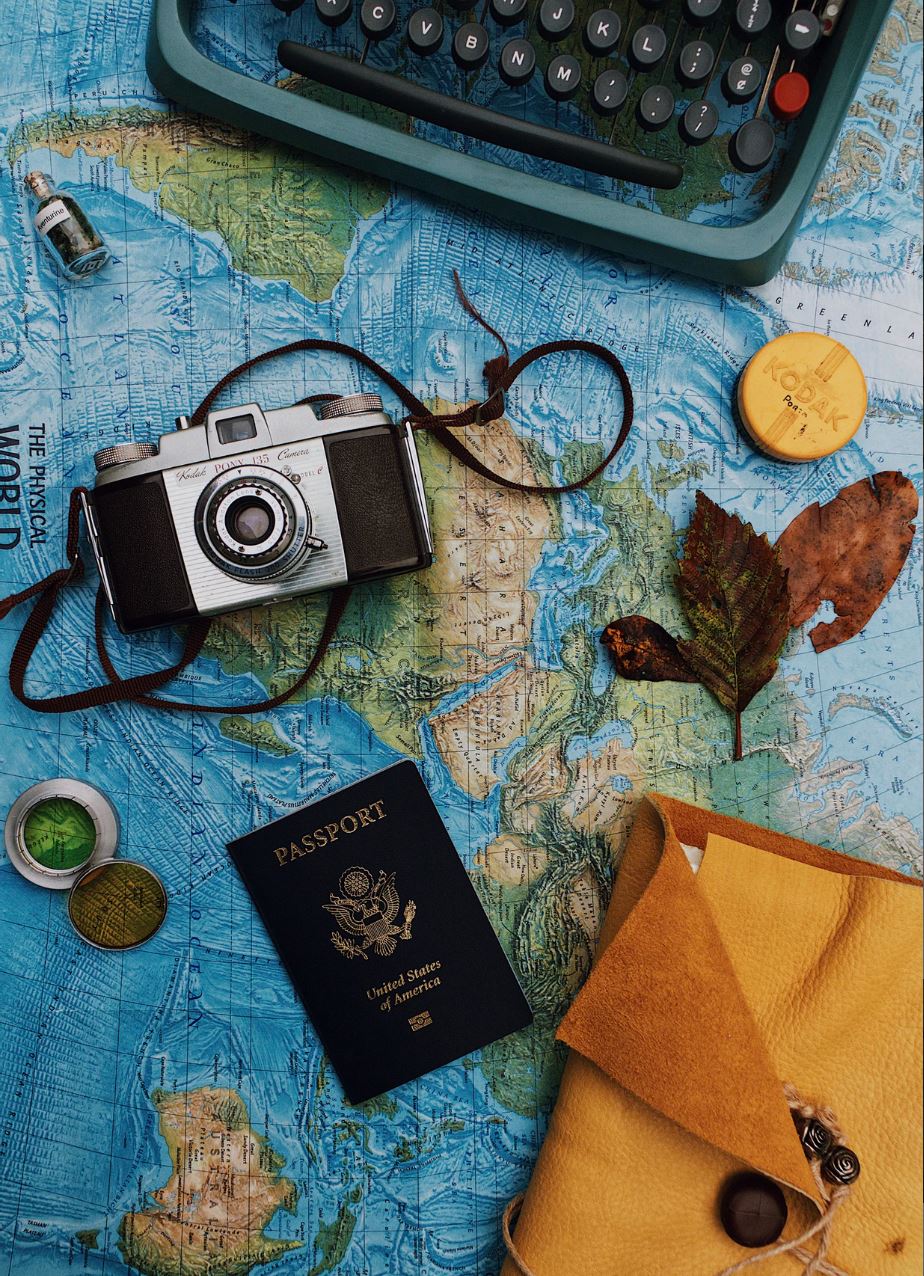 Camera, passport and typewriter on top of map image