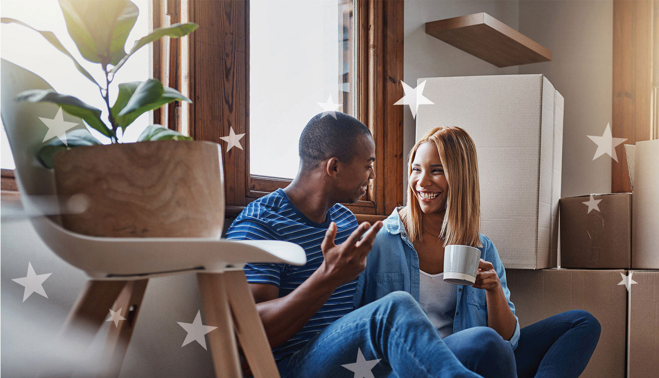 Young couple sitting in their new house surrounded by boxes.